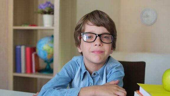 孩子戴着眼镜的小男孩在家厨房里学习写作业
