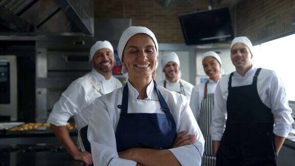 一群拉丁美洲的面包师面对镜头微笑着工作女领导交叉双臂站在前台