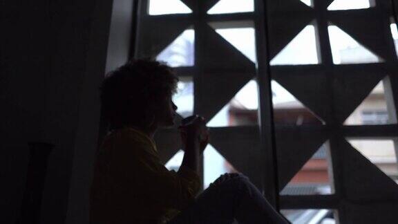 在家窗台上喝茶的女人在沉思