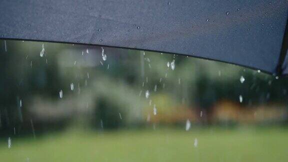 阳光明媚的夏雨水珠从灰色的伞面上流下来