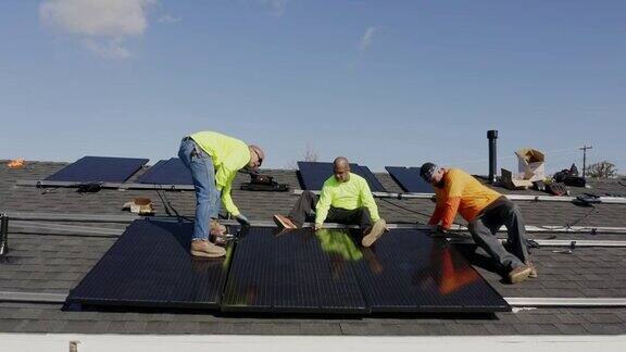 在加利福尼亚的住宅屋顶安装太阳能电池板的工人团队