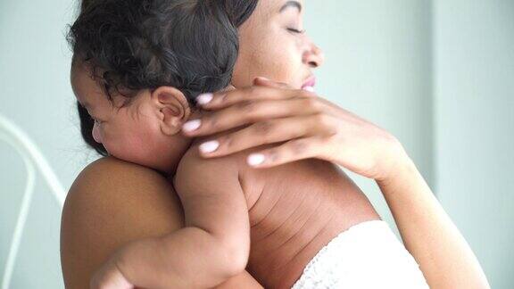 侧视图:美丽的非洲母亲抱着小男孩在家里睡觉
