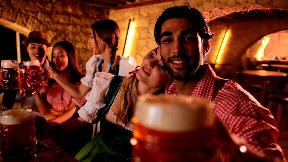 年轻的多民族朋友在传统的酒吧里喝着啤酒庆祝啤酒节