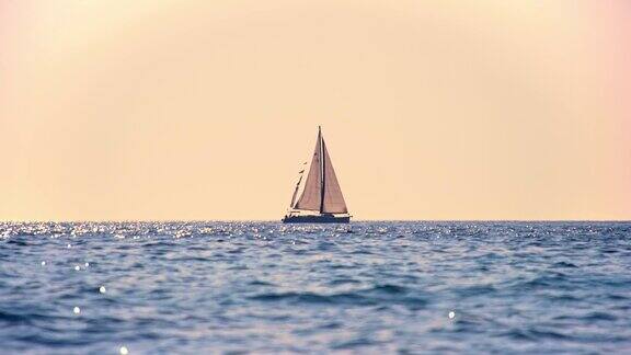 日落时在地平线上航行的帆船