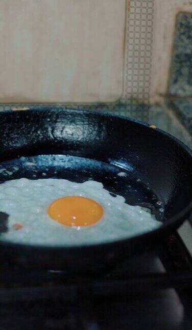 在煎锅里煎鸡蛋的人特写