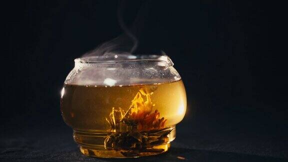 绿茶花蕾在玻璃茶壶中绽放