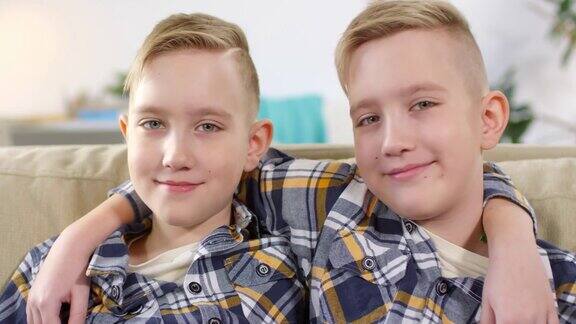 在沙发上摆姿势的白种同卵双胞胎