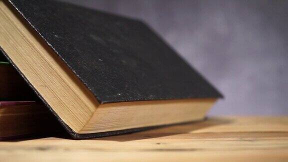 旧木桌上放着书美丽的黑色背景