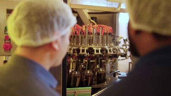 4K白酒厂工人在生产线上检查白酒洗瓶机
