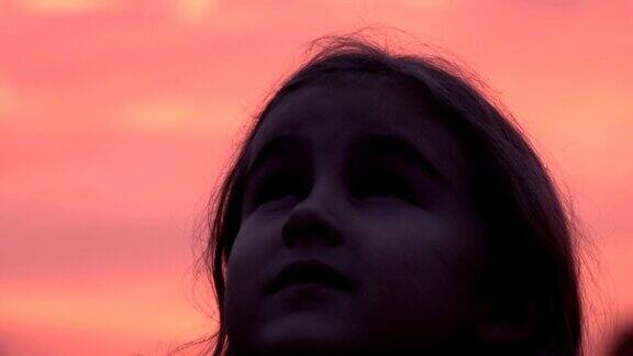 孩子在大自然中仰望天空小女孩祈祷着仰望着紫色的天空带着希望特写