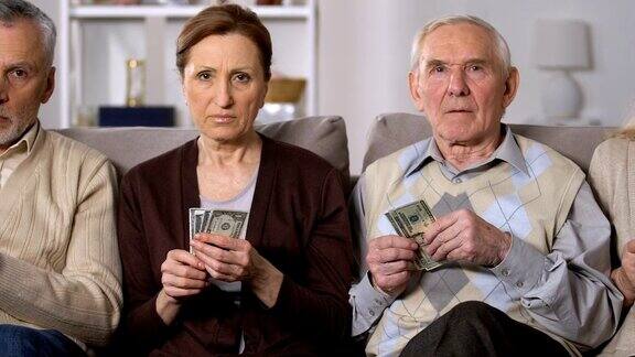贫穷的老年人坐在沙发上数钱金融不稳定危机