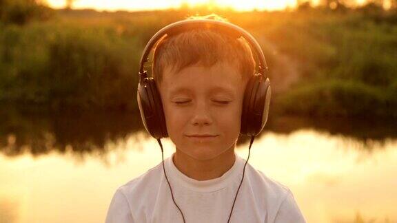 男孩戴着耳机在夕阳下听音乐