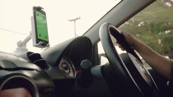 绿屏:亚洲女商人驾驶一辆装有智能手机的汽车