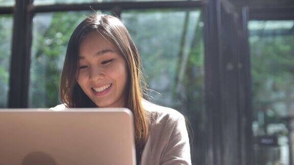 近距离观察亚洲女性在咖啡馆使用笔记本电脑