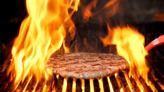 当为汉堡或汉堡在餐厅厨房烹饪肉类时火焰在慢镜头中燃烧美味的肉正在烧烤架上烤着全高清