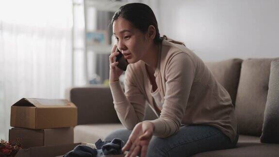 亚洲女人消费者觉得坐沙发不好拿着电话与网店谈论家里订购的问题产品打电话投诉