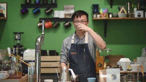 亚洲华人咖啡师在咖啡厅柜台制作咖啡粉