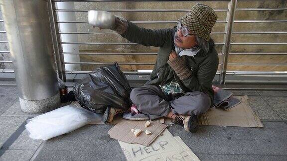 一个无家可归的人在呼吁人们给予一些东西