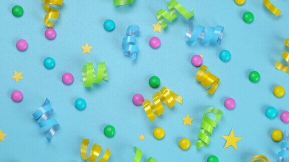 旋转蓝色背景与彩色糖果和蛇或丝带的蓝色背景生日周年纪念祝贺