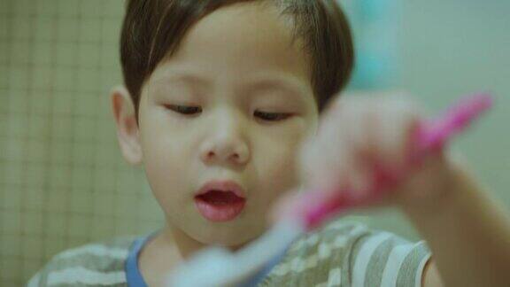 亚洲小孩男孩蹒跚学步的小孩在晚上洗澡的时候用儿童牙刷刷牙