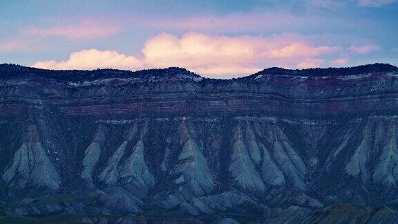 日落时粉红色的云在科罗拉多州西部的Bookcliffs山脉(落基山脉)上缓缓翻滚