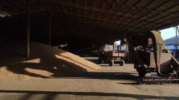 旧的苏联农业设备用旧拖拉机和堆积如山的小麦收割