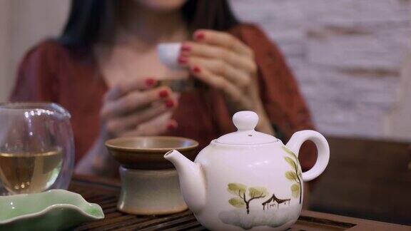 东方饮茶文化中国饮茶仪式上桌上有泡茶设备喝中国乌龙茶或白茶的妇女