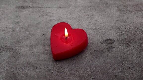 红色心形蜡烛和烛光孤立在石头背景4K浪漫的情人节夜晚概念