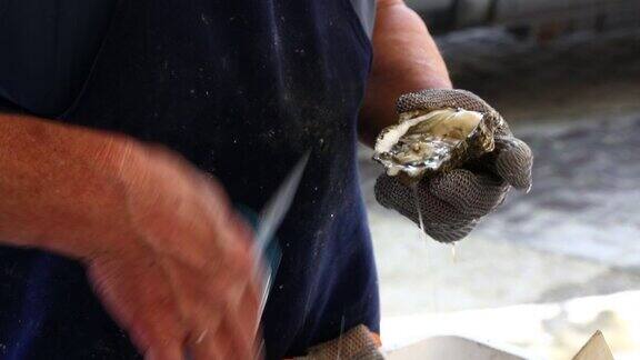 一名男子在关闭的市场打开新鲜的牡蛎