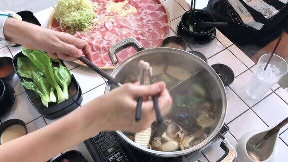 泰国曼谷将猪肉切片放入火锅中