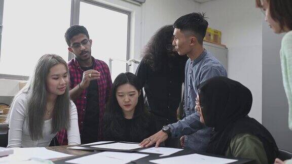 亚裔马来男教师反馈检查他的学生工作
