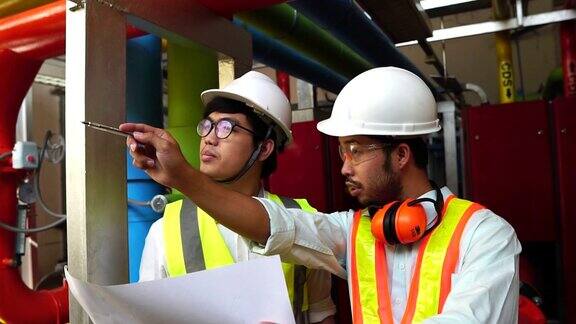 慢镜头:两名工程师在亚洲检查工业机器人控制系统