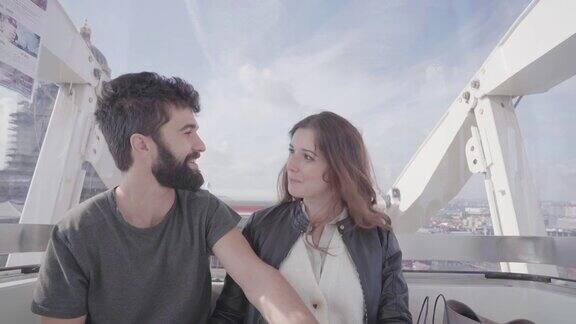 相爱的情侣一起坐在浪漫的摩天轮上看着地标建筑和布鲁塞尔的