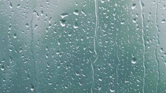 真正的雨滴滑在窗户玻璃上