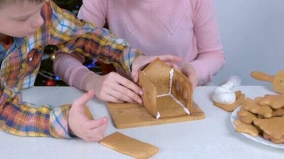 妈妈和儿子做姜饼的房子连接细节用糖甜糖霜