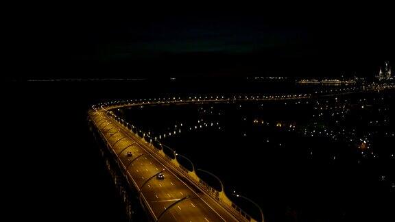 鸟瞰图汽车行驶在夜间桥梁上的背景现代城市建筑