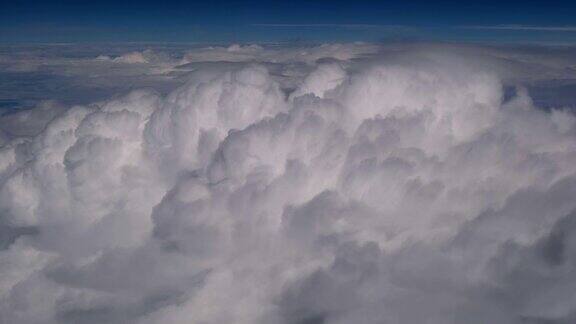 从蓝色天空的飞机窗口俯瞰云层的惊人镜头从飞机窗口望出去蓝天白云通过空中背景来解题实时录像