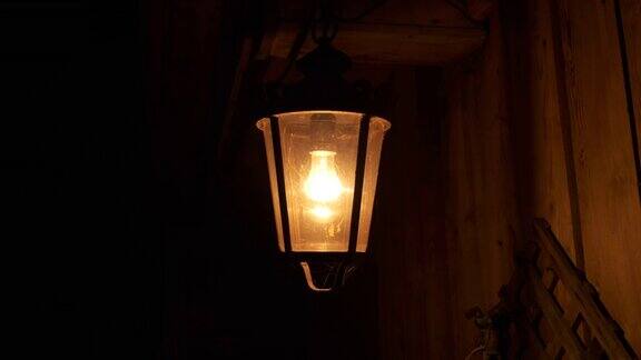夜幕降临村谷仓附近挂着一盏旧灯笼它灯火阑珊处风摇曳影子顺着木墙跑不祥的气氛黑暗灯笼、电灯暖光黑夜它在风中摇曳