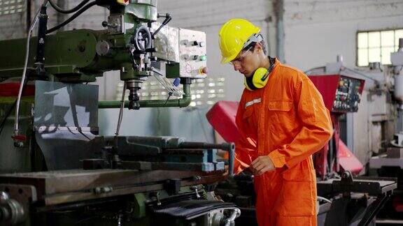 一个穿着橙色制服的男性技术员正在修理一台坏了的机器