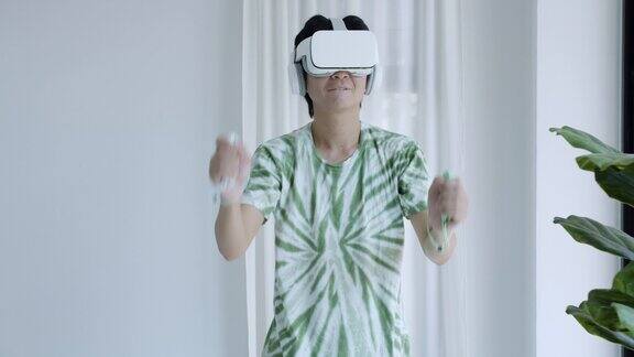 亚洲男子使用VR眼镜在家庭办公室玩游戏