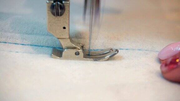 中年妇女在米色织物缝纫机上手工缝制