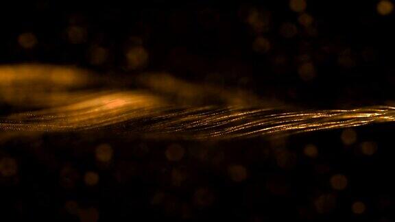 圣诞数码闪烁金色颗粒横条纹和散景在黑色背景上流动节日圣诞事件