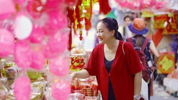 4K亚洲成熟女子购买装饰饰品庆祝中国农历新年在中国城市场