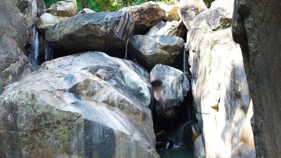 瀑布溪流在山上野生丛林的天然瀑布全景从岩石瀑布流下的山河水野生自然景观