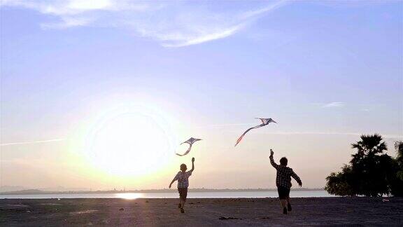 快乐的两个孩子男孩带着风筝奔跑在沙滩上