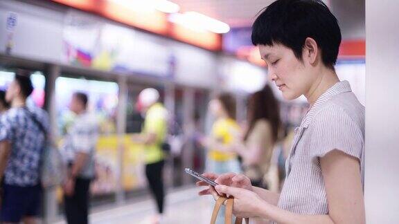 一名女子在地铁站使用智能手机