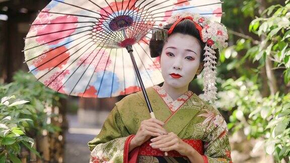 舞妓(正在训练的艺妓)在京都祗园狭窄的人行道上行走