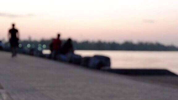 迷离的跑步者正在公园里以黄昏和河流为背景跑步锻炼身体