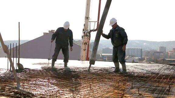 工人们在建筑物顶部浇筑混凝土