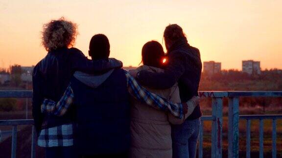 夕阳西下时四个朋友在桥上闲逛